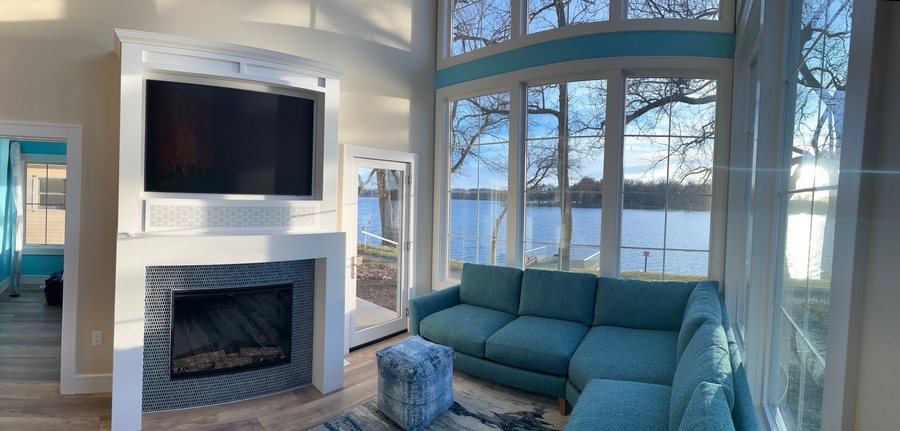 Lake house living room with a framed TV above the fireplace