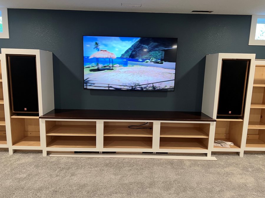 Media wall with a mounted TV between tower speakers