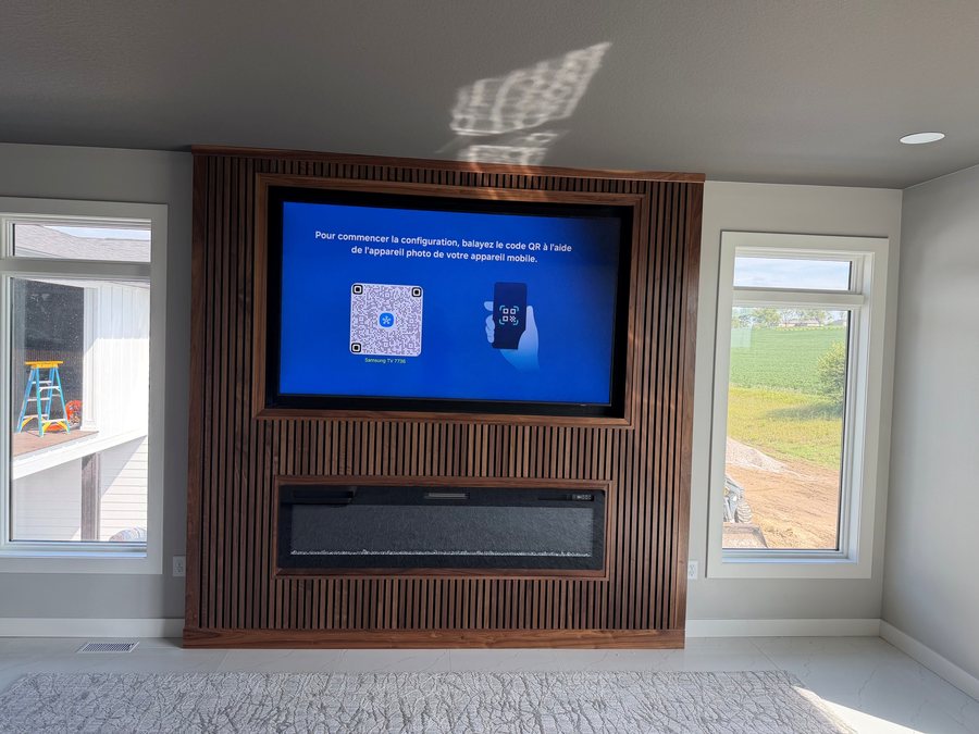 Wood slat media wall with a mounted TV above a linear fireplace