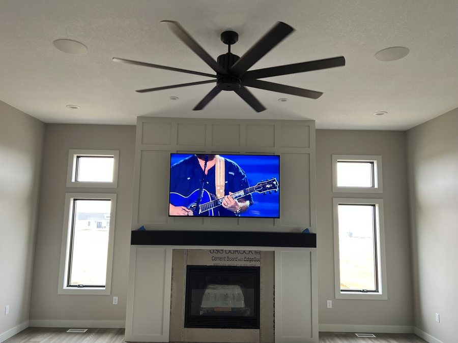 Great room TV above a fireplace with in-ceiling speakers