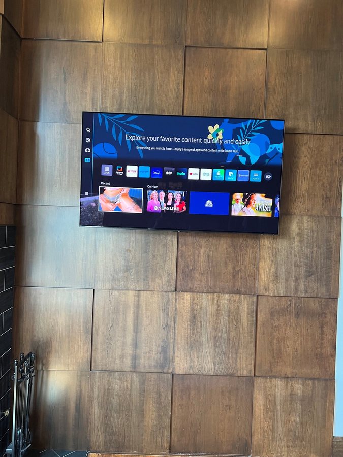 TV mounted on a textured wood panel feature wall