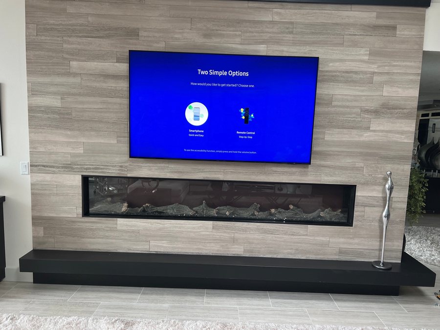 Floating TV over a long linear fireplace on a tile wall