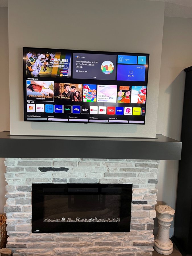 Wall mounted TV over a whitewashed brick fireplace