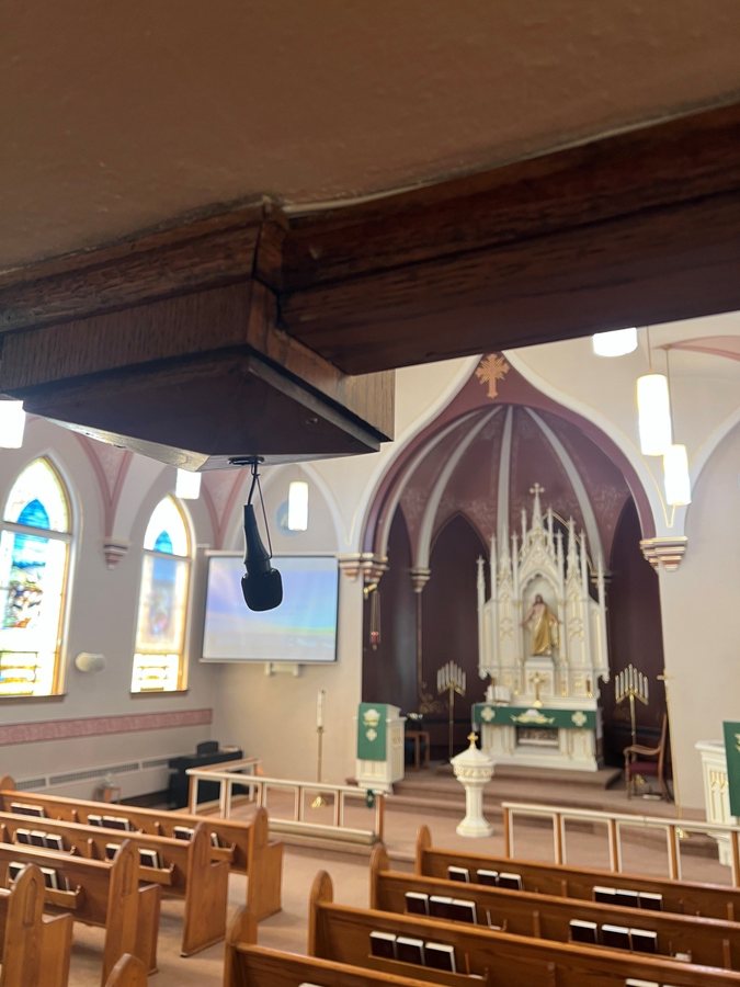 Church sanctuary with mounted displays and ceiling speaker